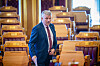 Bjørnar Skjæran står i en tom stortingssal med trepanel og gule seter etter spørretimen.