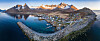 Panoramautsikt over Mefjordvær med havn, vei, fjell og blått hav på Senja.
