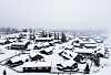 Luftfoto av snødekte hytter og skogkledd landskap på Skeikampen.